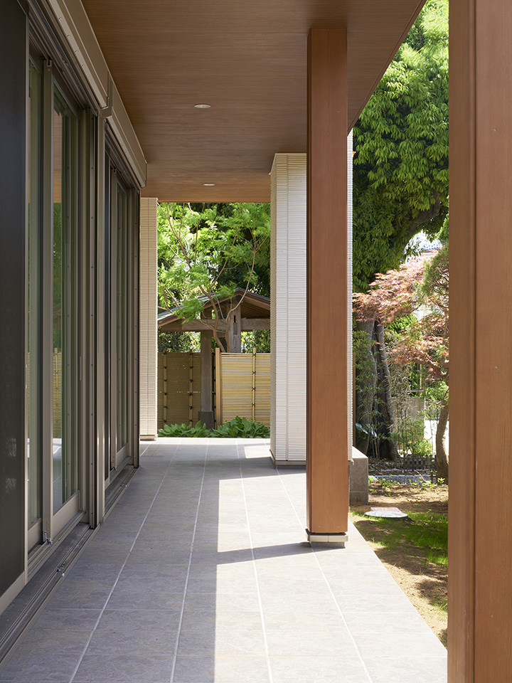 木のルーバーが緑と調和する家